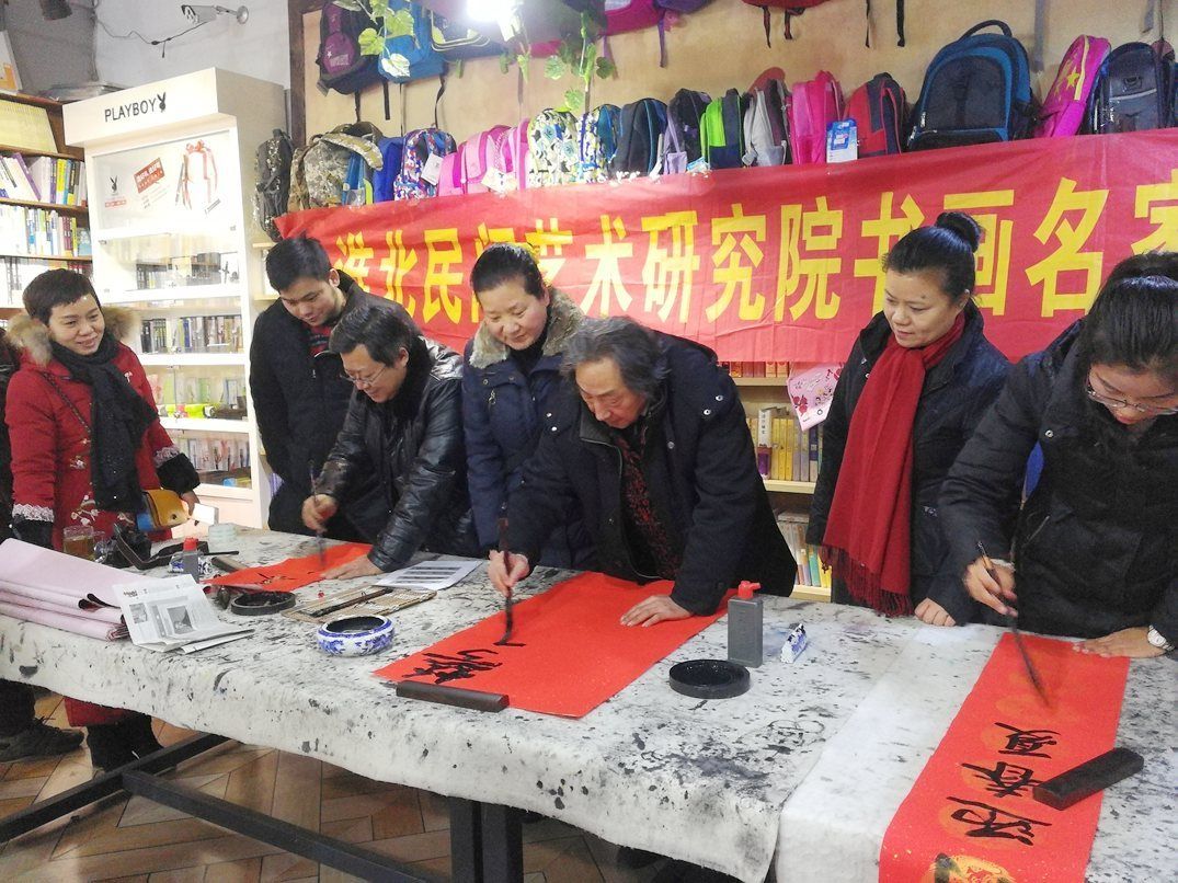 淮北民間藝術(shù)研究院攜手樹人文化生活館在安康路為市民送春聯(lián)