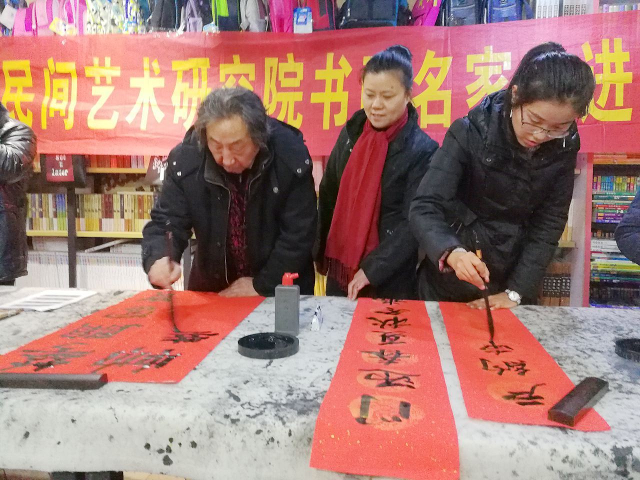 淮北民間藝術(shù)研究院攜手樹人文化生活館在安康路為市民送春聯(lián)